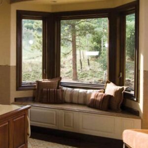 A bay window with wood interior frames is set up as a cozy sitting area.