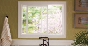 A modern sliding window with white frames inside of a well-decorated bathroom.
